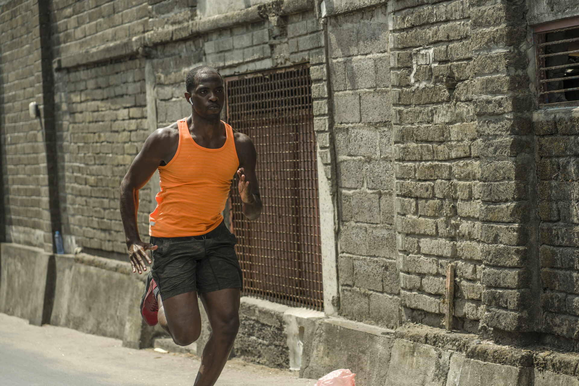 urban runner workout . Young attractive and athletic black African American man running outdoors on asphalt road training hard jogging in sport sacrifice commitment and healthy lifestyle concept